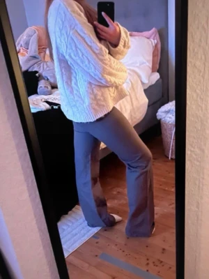 Grönaktiga bootcut byxor  - Grönaktiga byxor med bootcut-modell. De har en mjuk och stretchig känsla som gör dem riktigt bekväma att bära. Perfekta för dig som vill ha en trendig siluett med utsvängda ben.Coola byxor i en grå grön färg. Super snygga och har en bra passform och är normal i storleken. Sitter bra på. Jag tycker de är lite bootcut och low waisted men andra kan ju tycka annat. Super fina och snygga iaf. Två av knapparna på hållarna är lösa (inte knapparna bara tyget men det syns inte och det sitter, lätt sytt).