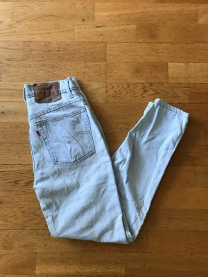 Ljusblå Levi's 512 jeans - Säljer ett par ljusblå Levi's 512 jeans med klassisk femficksdesign och hög midja. Jeansen har raka ben och är tillverkade i bomull. Snygg vintagekänsla med rå kant upptill och ikonisk läderpatch bak. Perfekta för en avslappnad och trendig look.