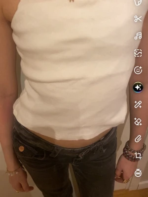 Vit ribbad croppad linnetopp - Säljer en enkel och stilren vit ribbad linnetopp med smala axelband. Toppen är croppad och har en rak passform som passar perfekt till jeans eller kjol. Materialet är mjukt och stretchigt för en bekväm känsla.