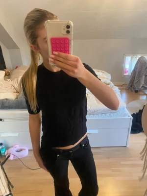 Svart stickad basic t-shirt  - En enkel svart stickad t-shirt med korta ärmar och rund hals. Har en normal passform som funkar till det mesta. Perfekt att matcha med jeans eller kjol för en clean look.