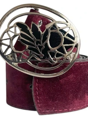 Vinrött bälte  - Vinrött bälte i sammet- och lädermaterial med silver-svart spänne❣️Totala längd (utan spänne): 90.6 cm. Jag brukar ha strl S i byxor för referens!