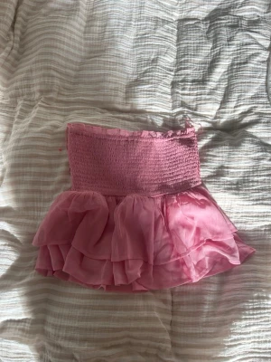 Rosa tubtopp - Rosa tubtopp med volang. Perfekt färg till sommaren. Sitter fint med luftigt material.