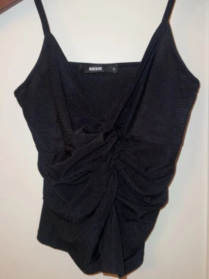 Svart ribbad linnetopp från BikBok - Snygg svart linnetopp från BikBok med smala axelband och ribbad struktur. Helt oanvänd, har dock inte prislappen kvar tyvärr. Pris går att diskutera. 💞 