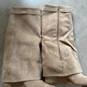 Stövlar - Snygga beige stövlar. Aldrig använda utomhus. Storlek 41 men passar mig som har 39/40. 
