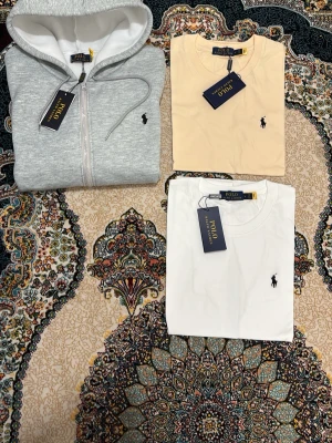Grå hoodie från Polo Ralph Lauren - Snygg grå hoodie från Polo Ralph Lauren med dragkedja framtill och klassisk huva med dragsko. Ikoniska broderade loggan på bröstet. Mjuk insida och stilren design, perfekt för en avslappnad look.