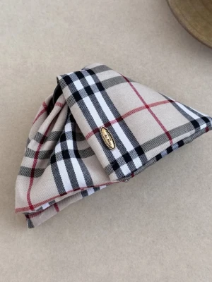 Burberry Hårklämare - Trendig hårklämma med klassiskt rutigt mönster i beige, svart, vitt och rött. Klämman har en snygg guldfärgad detalj och en mening som säger ” Love is forever” den mest perfekta presenten för din tjej eller nära och kära