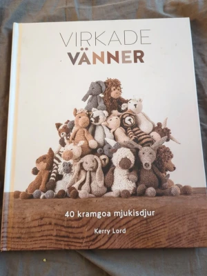 Virkade vänner av Kerry Lord - Boken 'Virkade vänner' innehåller 40 mönster på virkade mjukisdjur. Omslaget är vitt med en hög av virkade djur i olika färger. Perfekt för dig som gillar handarbete och vill skapa egna gosedjur. Inbunden bok med tydliga instruktioner och inspirerande bilder.