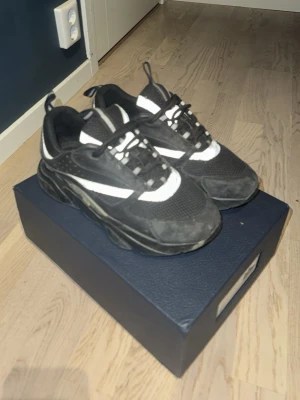 B22 - Chunky sneakers i svart med vita detaljer och grov sula. Ovandelen är i mesh och mockaimitation, med svarta skosnören och vita inslag längs sidorna och tungan. Perfekta för en streetwear-look och passar till många outfits.