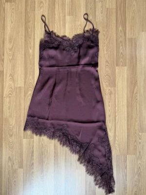  Plommonfärgad spetsklänning från H&M  -  En plommonfärgad spetsspänning med dragkedja på vänster sida 