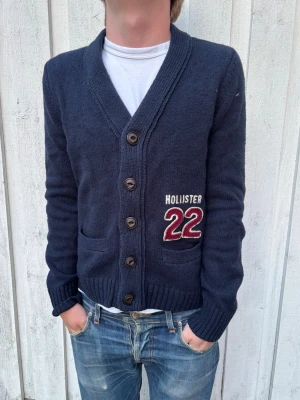 Marinblå Hollister Cardigan - En mycket trevlig kofta från Hollister med en extremt bra passform! Modellen är 178 cm och väger 68 kg. M, passar också S! Hör av dig vid frågor!
