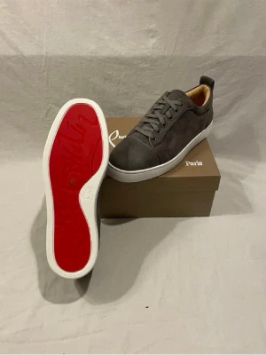 Gråa Louboutin sneakers med röd sula - Säljer mina Christian Louboutin skor som jag fick i present gillar it dom så säljer dom. Köpt för 1999kr på Plick. Försöker få samma tillbaka men vid snabb affär kan jag gå ner någon hundring . Skick 10/10 helt oanvända. Stl 43 allt ingår som ni ser på bilderna. Skriv vid intresse svarar på alla frågor !!