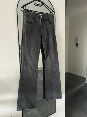 Lågmidjade svartgrå jeans - Väldigt fina svart/gråa bootcut jeans från ginatricot young i mycket bra skick med häftiga fickor. 💕