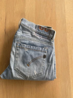 Dondup Jeans - Snygga Blåa jeans från Dondup med klassisk femficksdesign och en slim passform. Jeansen har en diskret tvättad look med snygga slitningar och är tillverkade i stretchigt denim för en bekväm passform. Perfekta för en stilren och modern look.