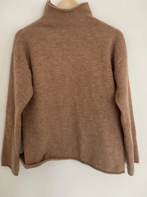 Brun stickad polotröja - Trendig brun stickad polotröja med avslappnad passform och långa ärmar. Tröjan har en hög krage och är tillverkad i ett mjukt material❣️