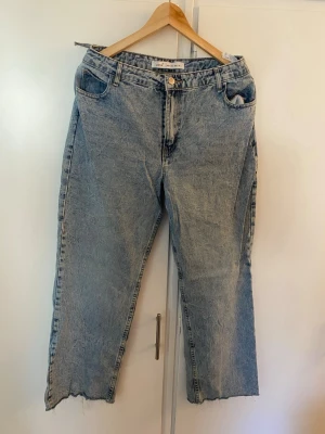 Ljusblå raka jeans med rå kant - Säljer ett par ljusblå jeans från ONLY med rak passform och rå, fransig kant nertill. Jeansen har klassisk femficksdesign och stängs med knapp och dragkedja. Perfekta för en avslappnad och trendig look.