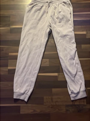 Beigea mjukisbyxor  - Säljer ett par biegea mjukisbyxor med resår i midjan och muddar vid bensluten. Skön passform och är tillverkade i mjukt material som passar perfekt för chill dagar. Klassisk rak modell från H&M