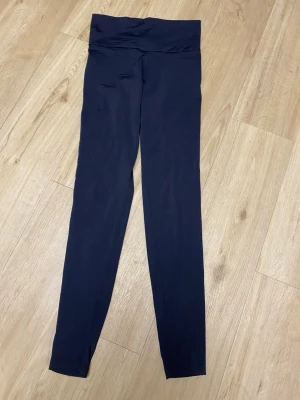 Açaí BERRY svart leggings - Svarta leggings med hög midja och en bred linning. De har en slät design utan synliga sömmar framtill, vilket ger en ren och strömlinjeformad look. Baktill finns sömmar för att framhäva rumpan. Saknar storlek, men uppskattar dessa till XS. Välanvända därav lågt pris! 