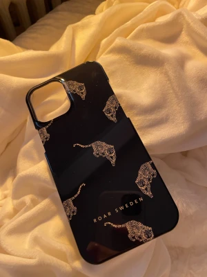 Blått mobilskal med leopardmönster - Snyggt blått mobilskal från Roar Sweden med glittriga leopardhuvuden som motiv. Skalets yta är blank och designen är modern och stilren. Skalet är till IPhone 12 Pro Max.
