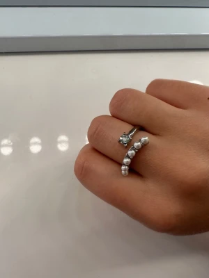 Snygg silverring med pärldetaljer - Säljer denna silverfärgade ringen med öppet band med pärlor som inte används🫶🏼🫶🏼