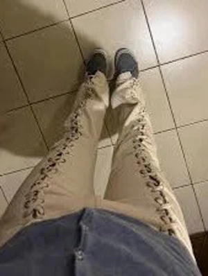 Beiga jeans med snörning i sidorna - Unika beiga jeans med cool snörning längs båda sidorna. Rak passform och hög midja ger en trendig siluett. Perfekta för dig som vill sticka ut och addera något extra till din outfit. Materialet ser ut att vara denim med snygga detaljer.