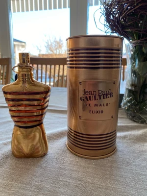 Jean Paul Gaultier Le Male Elixir 125ml med kvitto - Jean Paul Gaultier Le Male Elixir parfym i en unik guldskimrande flaska formad som en manlig torso. Kommer med en matchande guldfärgad metallburk. Doften är intensiv och exklusiv, perfekt för dig som vill sticka ut. Ungefär 100ml kvar. Säljer pga pengar behov