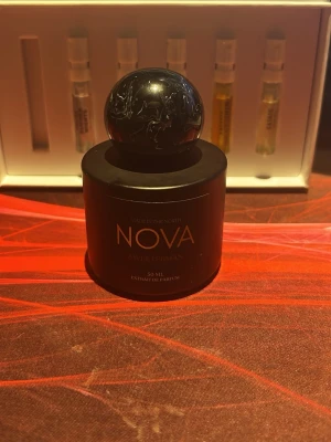 BYTE! - Stilren parfymflaska från NOVA med doften Sweeterman. Flaskan är matt svart med rundad form och stor klotformad kork. Texten är i guld och orange, vilket ger en lyxig känsla. Innehåller 50 ml extrait de parfum.