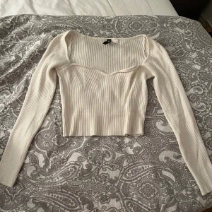 Långärmad tröja  - Vit, långärmad, ganska kort tröja i lite tjockare material. Storlek S/36. Endast använd fåtal gånger. Säljer då den är för liten och för kort i armarna. 