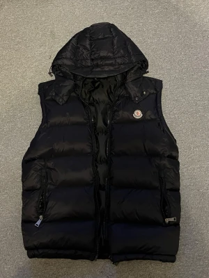 Moncler väst - Säljer min Moncler Väst då den inte används och bara samlar damm. Avtagbar luva oxå