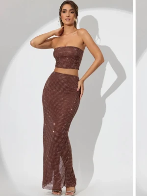 Brunt glittrigt set med bandeau - Säljer en brun långkjol med tillhörande topp med glittriga detaljer. Kjolen har en tight passform som framhäver figuren och en slits baktill för extra rörelsefrihet. Perfekt för dig som vill ha en trendig och elegant look med shimmer.