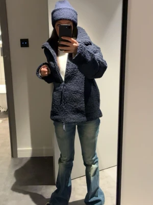 Mörkblå teddyjacka med dragkedja - Mysig mörkblå teddyjacka från Gina med hög krage och hel dragkedja framtill. Jackan har en avslappnad passform och är tillverkad i pile-material som ger en fluffig och varm känsla. Perfekt för kalla dagar och enkel att matcha med jeans eller andra outfits.