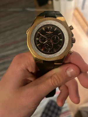 Breitling Bentley Special Edition klocka, utan box och kvitto - Snygg Breitling Bentley Motors Special Edition klocka med guldfärgat boett och svart gummiband. Klockan är en certifierad kronometer och tillverkad i Schweiz. Baklocket har Bentley-logga och detaljerad gravyr. Går med på bud och förhandling