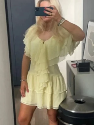 Ljusgul volangklänning med kort ärm - Söt ljusgul klänning med flera volanger och korta, fladdriga ärmar. Sjukt fin och inga defekter. Jätte populär och trendig. Perfekt till sommaren!! 