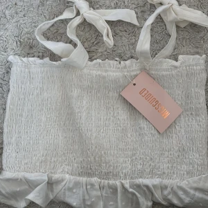 Urgullig topp med knytband - Jättegullig vit topp från missguided. Aldrig använd. I storlek 36/s. Kan gå ner i pris💕