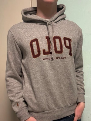 Grå Ralph Lauren hoodie - M - Säljer en snygg grå hoodie från Ralph Lauren. Den är i bra skick och har snygga röda detaljer. Storlek M.  Hör gärna av dig om du har frågor eller vill se fler bilder 😊  Allt gott från Deluxe garderoben ⭐️ 