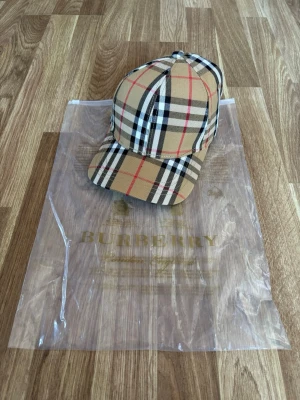 Burberry keps  - Hej säljer denna burberry keps. Säljer pga den inte passade mig för jag hade för mycket hår. Helt ny inga skador eller defekter.