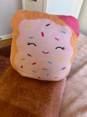 Squishmallow - En mjuk rolig pop tart squishmallow. Den är i mycket bra skick och har stått på en hylla som dekoration.