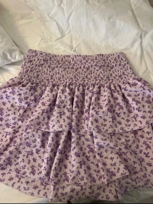 Lila blommig volangkjol Gina Tricot - Supersöt kort kjol från Gina Tricot i lila med små blommor och volangdetaljer. 💕