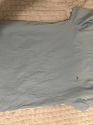 Ljusblå t-shirt från Gant - Snygg ljusblå t-shirt från Gant med liten broderad logga på bröstet. Klassisk rund halsringning och korta ärmar. Tillverkad i mjuk bomull som känns skön mot huden. Perfekt till jeans eller shorts för en clean look.