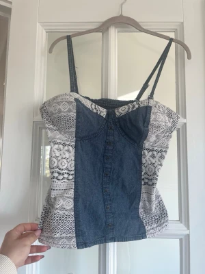 Jeans topp - Så cool och unik jeanstopp som tyvärr är förstor för mig. Perfekt som festtopp. Skulle säga att den passar en C/ D kupa, vadderade kupor. Jätte fint skick, inga defekter. Köpt i Paris. Står ingen storlek men skulle säga en S/ M med stor kupa. Stor rensar min garderob, massa jeans och klänningar uppe!! 