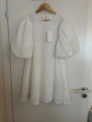 Studentklänning  - Superfin vit klänning från nakd. Stor i storleken, passar mig som brukar ha 36/S. Säljer för att jag bestämde mig för en annan klänning. Nypris 600kr