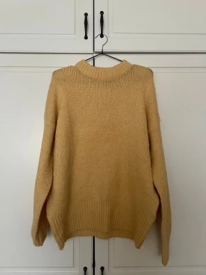 Beige oversized stickad tröja XS/S - Mysig beige stickad tröja i oversized modell med rund halsringning och breda ribbade muddar. Perfekt för lager på lager och enkel att styla till olika outfits. Tröjan är mjuk och har en avslappnad passform.