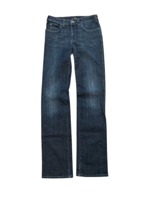 Blå jeans från Armani - Det står w28 men dom sitter som w27 Snygga blå jeans från Armani med klassisk femficksmodell och diskret logga på bakfickan. Jeansen har en mörk tvätt med lätt slitning och raka ben. Perfekta för en avslappnad men ändå stilren look.