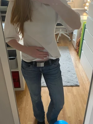 Svart tygbälte med metallspänne - Snyggt svart tygbälte med stilrent metallspänne. Perfekt till jeans eller byxor för en enkel och clean look. Bältet är justerbart och har en minimalistisk design som passar till det mesta. 