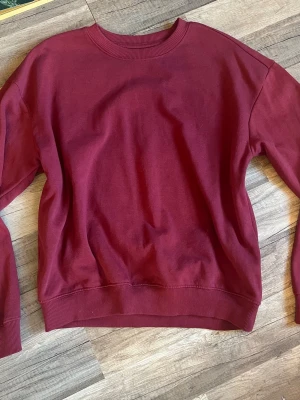 Vinröd sweatshirt från 157 - Vinröd sweatshirt från 157 med rund hals och ribbade muddar vid ärmslut och nederkant. Nästan aldrig använt och i nytt skick! Kontakta för frågor