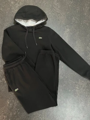 Lacoste tracksuit stl S-XS - Fräsh Svart set från Lacoste med matchande hoodie och byxor.                                              Storlek S kan passa xs                                     Använd skick