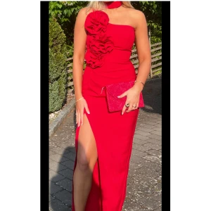 Röd balklänning - Säljer nu min älskade fina balklänning som jag tyvärr bara fått användning för en gång!!🥹❤️Klänningen fick en liten defekt i slitsen som jag för hand sytt ihop men som knappast syns! Skriv för tydligare mått eller närmare bild på defekten🙌🏼