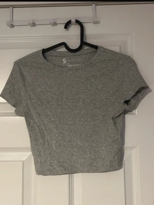 T-shirt - Enkel och clean ljusgrå topp som passar perfekt till höga jeans eller kjol. Ett stilrent plagg som funkar till både vardag och fest beroende på hur du stylar den.(ifrån new yorker) 