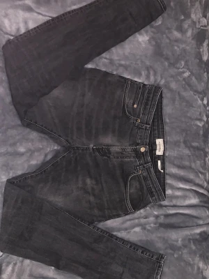 Svarta skinny jeans från Pull&Bear - Säljer ett par svarta skinny jeans från pull&bear med klassisk femficksmodell och hög midja. Jeansen har en snygg tvättad look och smala ben som sitter tight hela vägen ner. Perfekta till en avslappnad streetstyle.