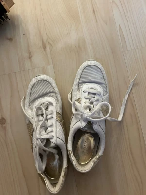 Vita och guldiga sneakers från Michael Kors - Hallå hallå säljer nu min tjejs michal kors skor i storlek 38/37 nästan aldrig använda väldigt bra skick! Bara skriva om ni undrar något😊 Pris går att diskutera! 