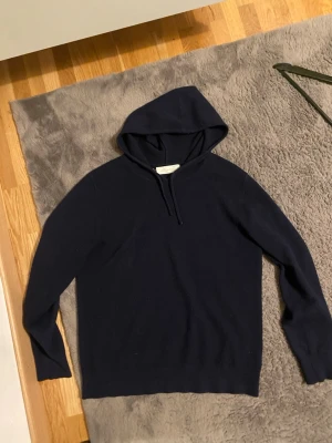 Mörkblå hoodie kasmire sayless  - Snygg mörkblå hoodie med klassisk huva och dragsko. Tillverkad i ett mjukt och bekvämt material som passar perfekt för en avslappnad stil. Hoodien har långa ärmar och enkel design utan tryck eller logga.storlek S!! Pris går att diskutera 